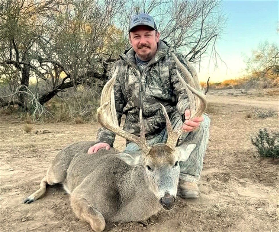 A hunter with a trophy South Texas whitetail at Legacy Ranch